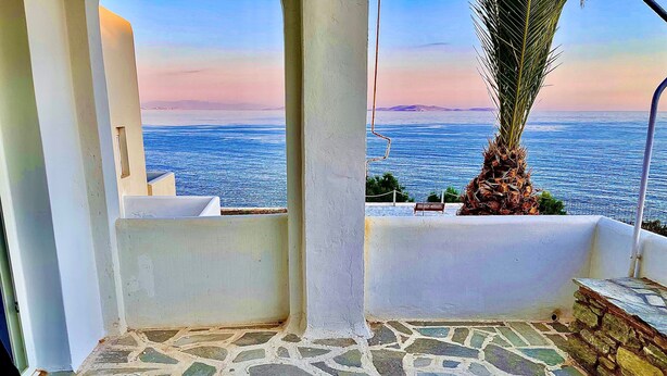 A stone-tiled balcony with a view of the sea and distant land. - Apartment 'Lefkopetra' with Shared Terrace, Wi-Fi and Air Conditioning (Tinos)