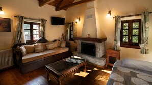 Una sala de estar acogedora con un sofá, chimenea y televisión instalada en la pared.