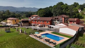 A residential area with houses, a swimming pool, and a view of mountains.