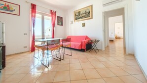 Una habitación con una mesa de comedor, sillas, un sofá y un cuadro en la pared.
