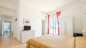 Un dormitorio con cama, televisión, armario y escritorio.