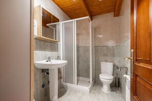 Ein Badezimmer mit Duschkabine, Waschbecken und Toilette.