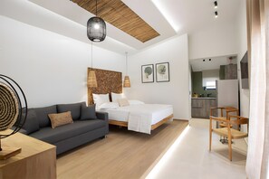 A modern bedroom with a bed, a sofa, a dining area, and a kitchen in the background. - Studio 'Elfam City Suite B' with Shared Terrace, Wi-Fi and Air Conditioning (Lefkada Town)