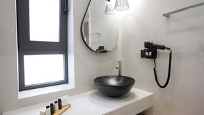A modern bathroom with a large mirror, a black vessel sink, a hairdryer, and a window. - Studio 'Elfam City Suite B' with Shared Terrace, Wi-Fi and Air Conditioning (Lefkada Town)