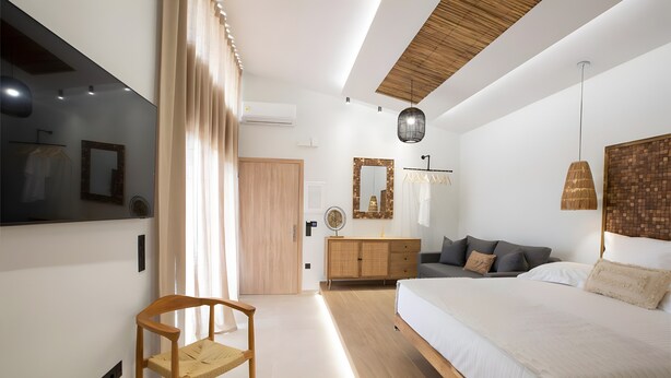 A modern bedroom with a large bed, wooden furniture, and a mirror. - Studio 'Elfam City Suite B' with Shared Terrace, Wi-Fi and Air Conditioning (Lefkada Town)