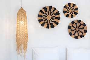 A wall with a hanging light fixture and three circular woven wall hangings. - Apartment 'Elfam City Suite A' with Shared Terrace, Wi-Fi and Air Conditioning (Lefkada Town)