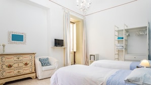 Un dormitorio con cama, cómoda, silla y armario.
