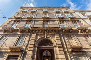 A multi-story building with a classical architectural style, featuring a central entrance with an archway, multiple balconies, and a series of windows. - Apartment 'The House In Baroque Style' with Wi-Fi and Air Conditioning (Catania)