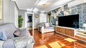 A living room with a sofa, a television, and a decorative wall. - Apartment 'Altea Beach' with Sea View, Wi-Fi and Air Conditioning (Altea)
