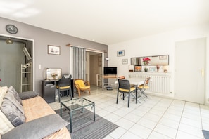 Un salon moderne avec un canapé, une table basse et un coin repas.