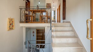 A staircase with a metal railing, a wooden bench, and a wall-mounted coat rack.