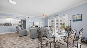 A modern living space with a dining area, kitchen, and seating area. - Palm Beach B31 Gulf Front 3BR 2BA Corner Unit (Orange Beach)