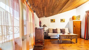 Un plafond en bois, un canapé blanc avec des coussins, une table en bois et un meuble en bois.