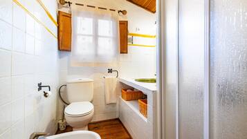 Un baño pequeño con inodoro, lavamanos y bañera.