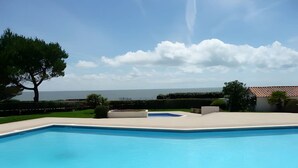 A swimming pool with a clear view of the sea in the background. - Le Petit Voilier 'Family Spirit & Ocean' with Private Pool and Garden, PO30 (Pornic)