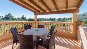 A covered outdoor seating area with a table and chairs, a balustrade, and a view of the landscape. - Villa 'Viñas Ref 259' with Mountain Views, Private Pool and Wi-Fi (Son Servera)