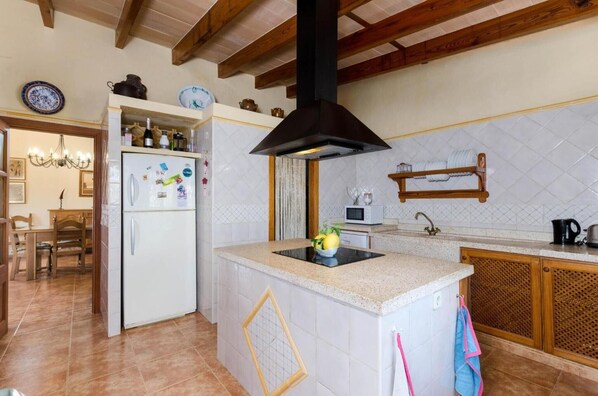 A kitchen with a central island, a microwave, and a sink.