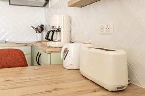 A kitchen with a coffee maker, toaster, and a power outlet on the wall. - Studio 'A011 - Old Port View Pornic' with Wi-Fi (Pornic)