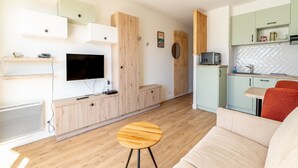 Un appartement moderne comprenant un salon, une cuisine et un coin repas.