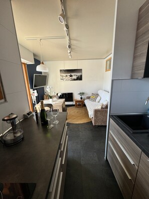 Una cocina moderna con comedor, televisor de pantalla plana y una cama con vistas.