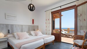 A bedroom with a bed, bedside tables, a reading chair, and a balcony with a view. - Country House 'Ses Penyes' with Sea View, Wi-Fi and Air Conditioning (Santanyí)