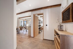 A modern interior with wooden beams, a dining area, and a chalkboard with text.