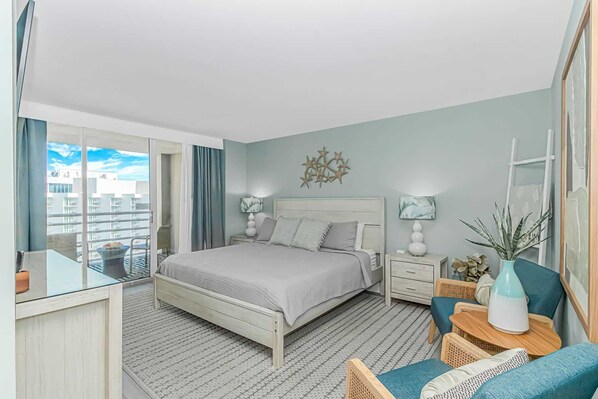 A bedroom with a bed, bedside tables, a chair, a mirror, and a balcony with a view. - North Hampton 1607 (Myrtle Beach)