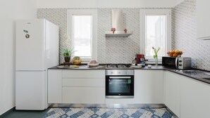 A kitchen with a refrigerator, oven, microwave, and a gas stove.