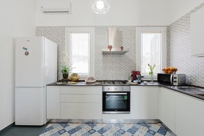 Cozinha equipada com geladeira, forno, micro-ondas e fogão a gás.