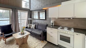 A modern kitchen with a built-in stove, white cabinets, and a grey sofa. - Stunning apartment in Ljørdalen (Ljørdalen)