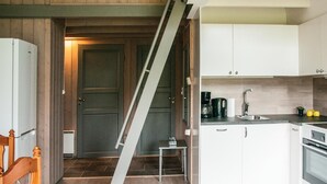 A kitchen with white cabinets, a stainless steel sink, and a coffee maker. - Stunning apartment in Ljørdalen (Ljørdalen)
