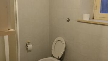 Een badkamer met toilet, bidet en wastafel.