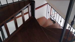 Una escalera de madera con barandillas y pasamanos de metal.