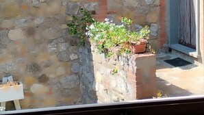 Un muro de piedra con una pequeña caja de macetas con plantas.