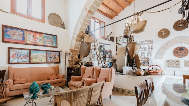 A spacious living area with a high ceiling, a sofa, chairs, a dining table, and various decorative items. - Apartment 'Torchio' with Shared Garden, Wi-Fi and Air Conditioning (Castelluzzo)