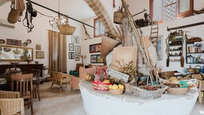 A rustic interior with wicker furniture, a central island with baskets, and various decorative items. - Apartment 'Torchio' with Shared Garden, Wi-Fi and Air Conditioning (Castelluzzo)