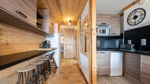 Une cuisine moderne avec des meubles en bois, un plan de travail noir et un lave-vaisselle blanc.