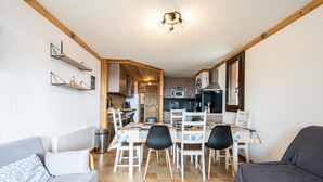 Une cuisine compacte comprenant un coin repas, un canapé et une petite table.