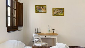 A bedroom with a bed, a desk, a chair, and two framed pictures on the wall. - Room 'Matrimoniale' with Wi-Fi (San Miniato)