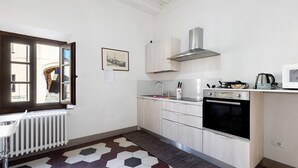 A kitchen with a window, white cabinets, a stove, and a radiator. - Room 'Matrimoniale' with Wi-Fi (San Miniato)