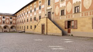 A building with a courtyard, multiple windows, and a staircase leading to the entrance. - Room 'Matrimoniale' with Wi-Fi (San Miniato)