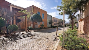 A cobblestone street with buildings, trees, and a clear sky. - Apartment 'Condomínio Do Vale' with Shared Pool, Shared Terrace and Wi-Fi (Guia)