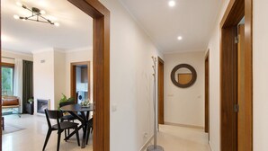 A modern interior with a dining area, a hallway, and a round mirror on the wall. - Apartment 'Condomínio Do Vale' with Shared Pool, Shared Terrace and Wi-Fi (Guia)