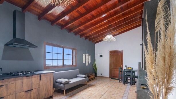 A spacious kitchen with wooden cabinets, a built-in stove, and a large window. - 'Canarian Retreat' with Sea Views, Private Terrace and Wi-Fi (Santa Brigida)
