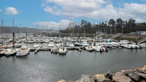 A marina with numerous boats docked, surrounded by trees and a clear sky. - Holiday Home 'Maison Au Port De Lézardrieux' with Private Garden, Balcony and Wi-Fi (Lézardrieux)