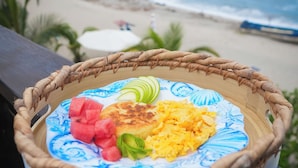 A wicker basket with a plate of food on a balcony overlooking a beach. - Luma at the beach (Santa Marta)