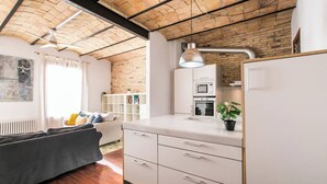 A modern kitchen with white cabinets, a built-in oven, and a microwave.