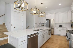 Lavavajillas, cafetera/tetera, utensilios de cocina, mesa de comedor