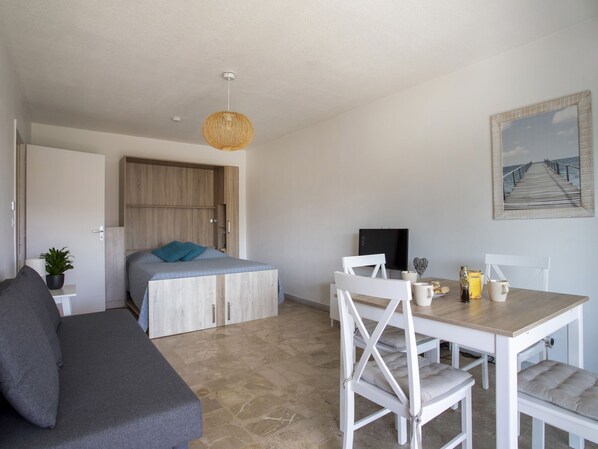 Un dormitorio moderno con cama, mesita de noche y lámpara colgante.