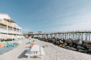 Guests can enjoy ocean views from the hotel's beachfront balconies, which feature white railings and offer access to beach chairs and a picnic table.